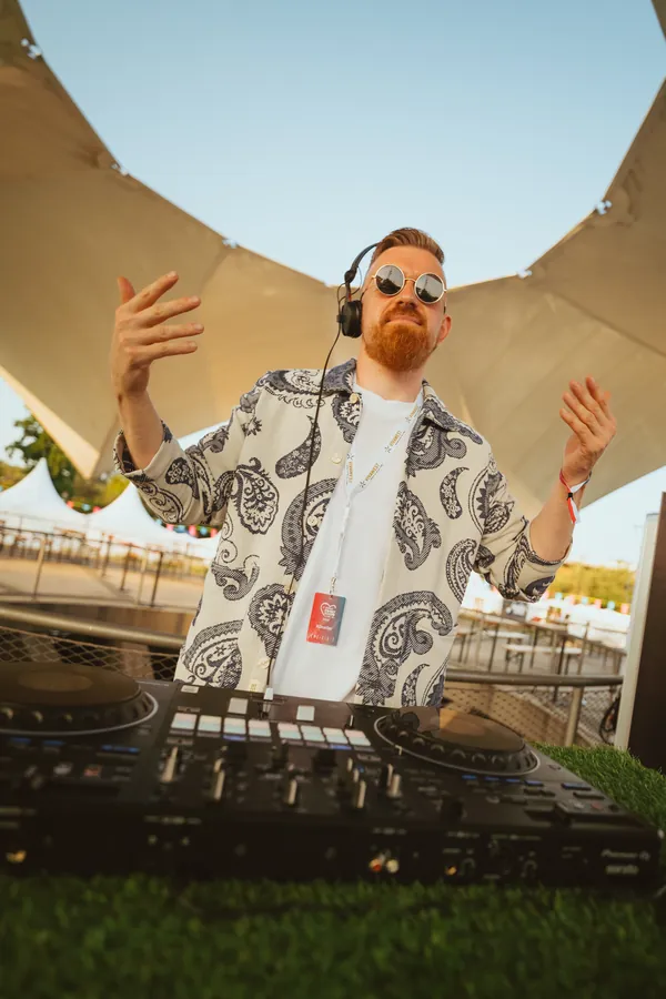 Dawid mit erhobenen Händen an der DJ Booth